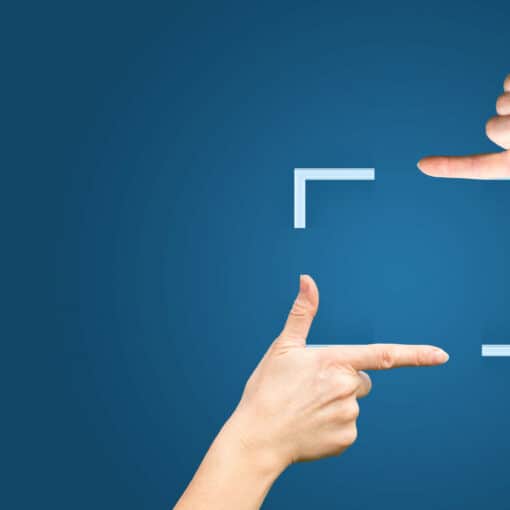 Female hands showing cropping composition gesture. Isolated on blue.