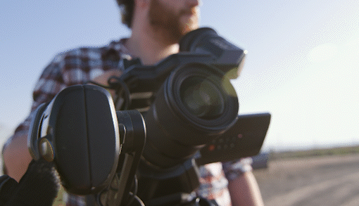 Cameraman looking into his camera on a sunny day