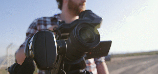 Cameraman looking into his camera on a sunny day